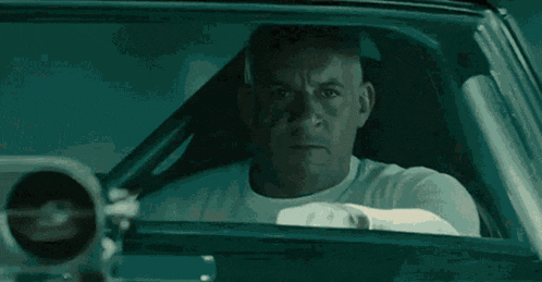 a man is sitting in the driver 's seat of a car .