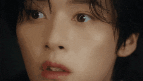 a close up of a woman 's face with her mouth open .