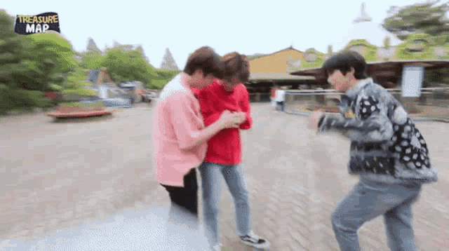 a group of young men are standing next to each other on a sidewalk .