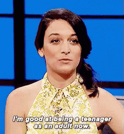 a woman is sitting in front of a blue screen and talking about being a teenager as an adult now .