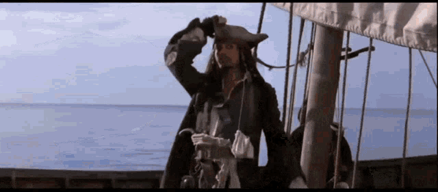 a man in a pirate costume stands on a boat in the ocean