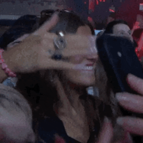 a woman taking a picture of herself with a blue phone