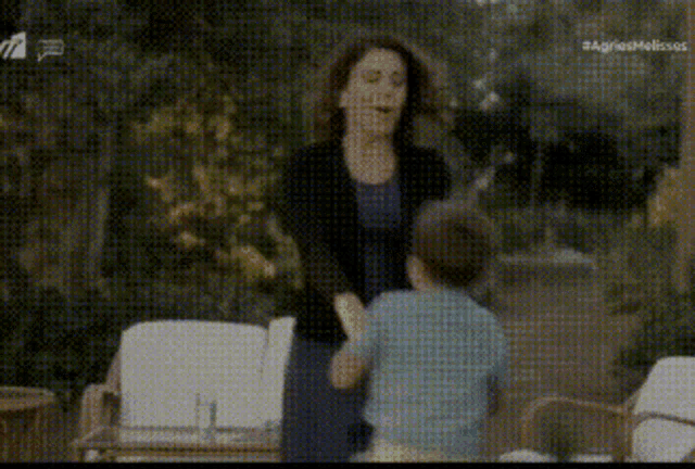 a woman is standing next to a young boy in a blurry photo
