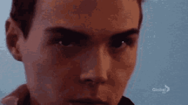 a close up of a man 's face with a blurry background and the word global on the bottom .