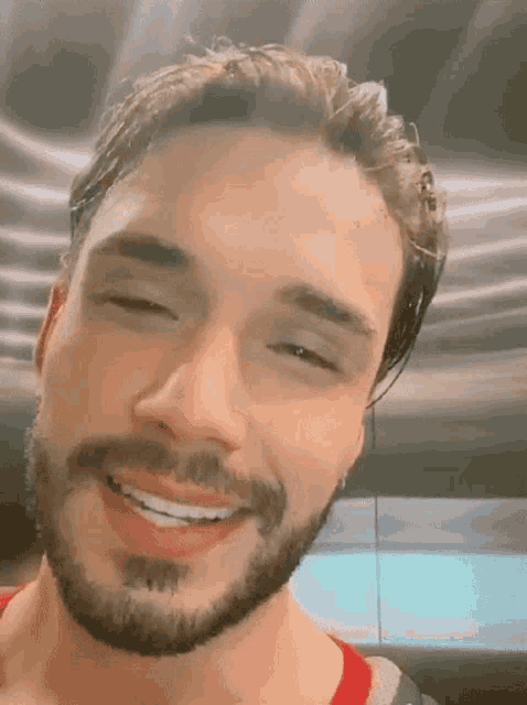a close up of a man 's face with a beard smiling