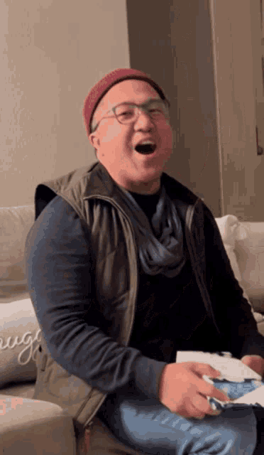 a man sitting on a couch with a pillow that says " laugh " on it