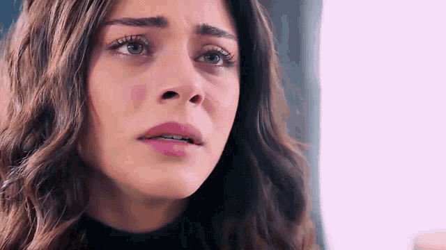 a close up of a woman 's face with tears coming out of her eyes