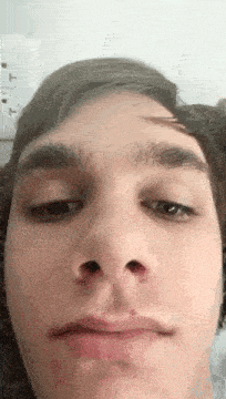a close up of a young man 's face with a red nose .
