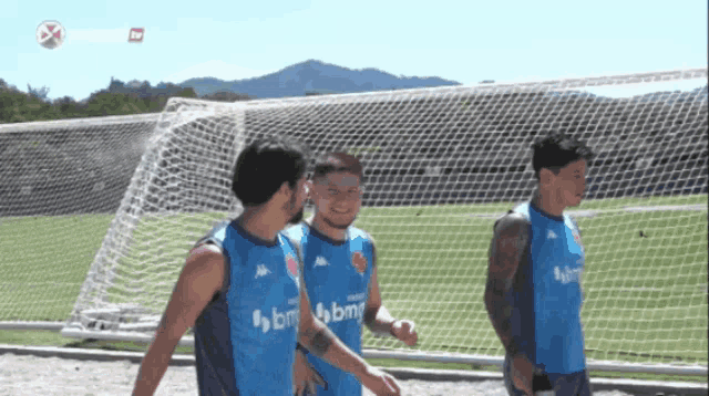 a group of soccer players wearing blue shirts with bm on them