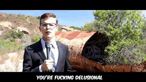 a man in a suit and tie is holding a microphone and saying you 're fucking delusional