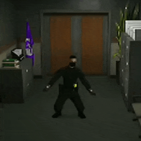 a man in a black uniform is standing in a hallway with his hands in the air
