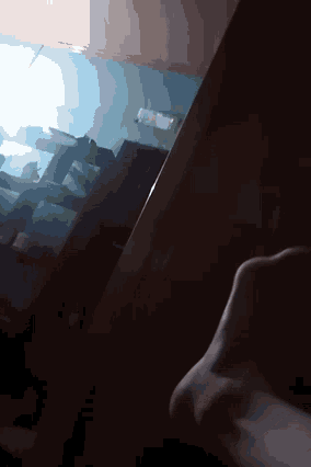 a person standing in a dark room with a light shining through the window