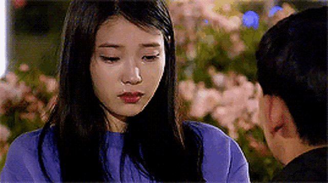 a woman in a purple shirt is looking at a man .