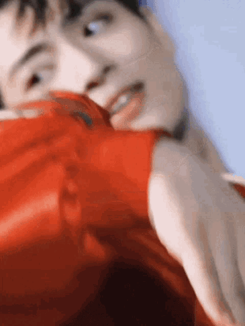 a close up of a man wearing a red jacket and smiling .