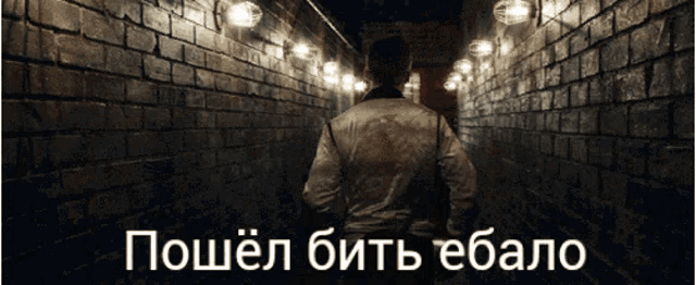 a man in a white jacket is walking down a dark hallway with a brick wall in the background