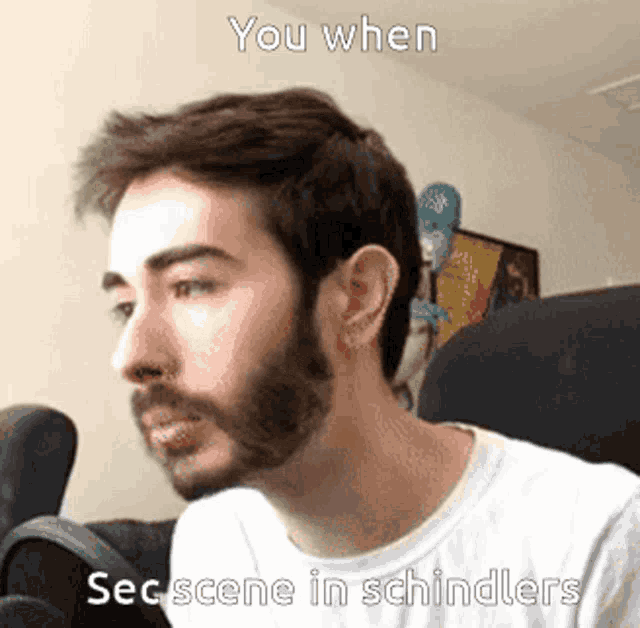 a man with a beard is sitting in front of a microphone with the caption " you when sec scene in schindlers " .