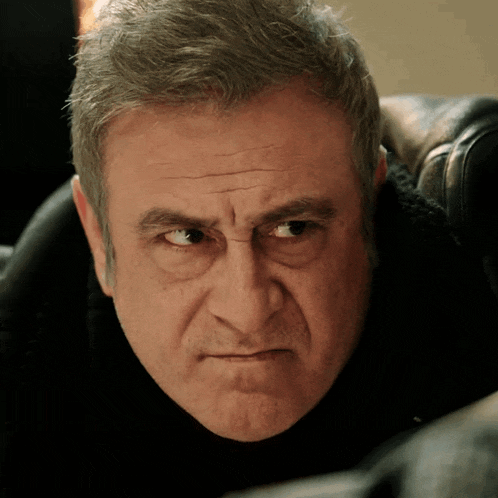 a close up of a man 's face with a serious look on his face
