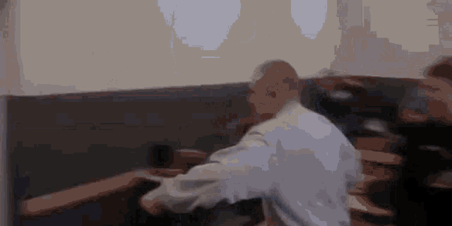 a man is sitting at a table with his arms outstretched .