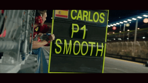 a man holding a sign that says carlos p1 smooth on it