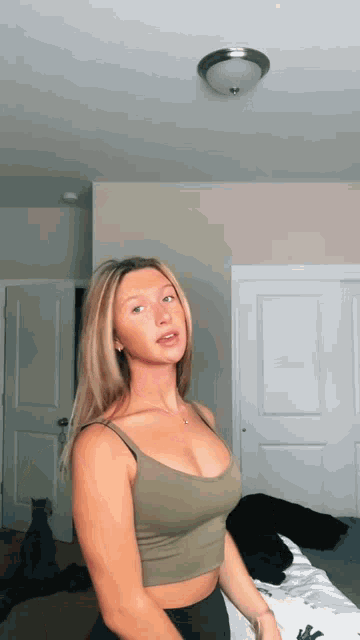 a woman in a green tank top is standing in a room