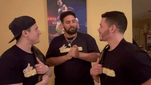three men wearing black shirts with the word kings on them are giving each other a thumbs up