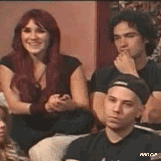 a group of people are sitting on a couch .