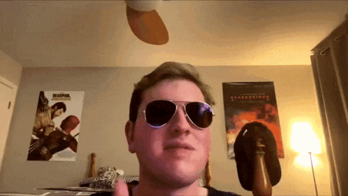 a man wearing sunglasses is giving a thumbs up