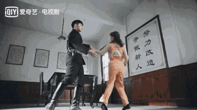 a man and a woman are dancing in front of a sign that says ' ioiyi ' on it