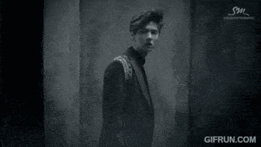 a black and white photo of a young man with sm entertainment written on the bottom