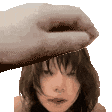 a hand is touching a woman 's forehead with a towel