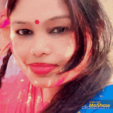 a close up of a woman 's face with a red bindi on her forehead