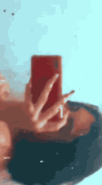 a person is taking a picture of themselves with a red phone