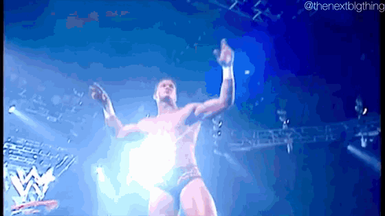 a man without a shirt is standing on a stage with his arms outstretched