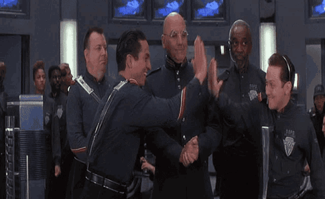 a group of men are shaking hands with one wearing a shirt that says ' s.p.d. ' on it