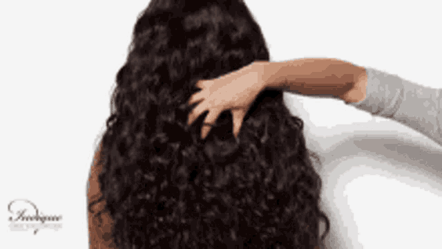 a woman with long curly hair is being touched by another woman