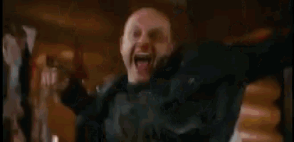 a man in a leather jacket is being thrown in the air by another man in a crowd .
