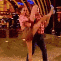 a man is carrying a woman in his arms while they are dancing .