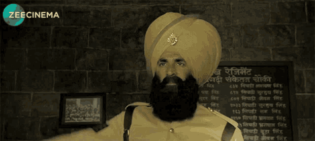 a man in a turban is standing in front of a zeecinema sign