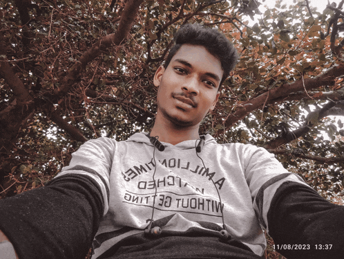 a young man taking a selfie wearing a shirt that says ' emil ' on it