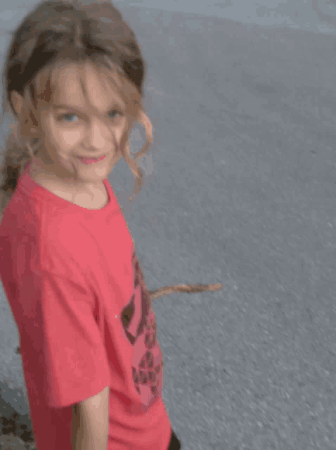 a young girl wearing a red t-shirt with a black skull on it