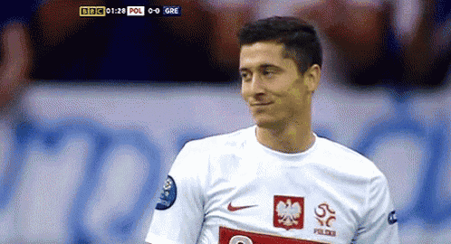 a soccer player wearing a white jersey with a red eagle on the front