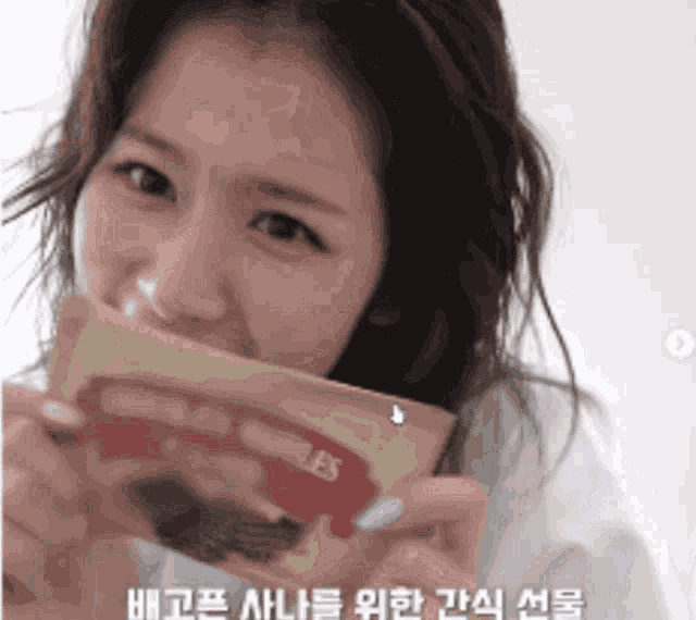 a woman is holding a piece of paper that says les on it