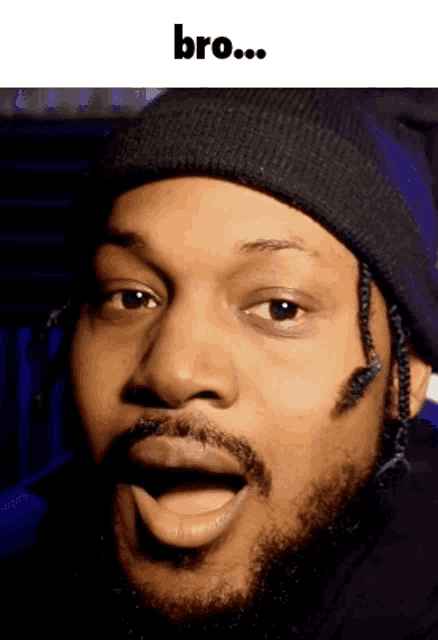 a man with a beard is wearing a beanie and making a funny face with the word bro below him