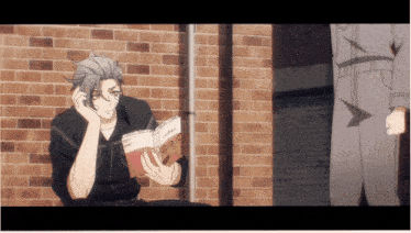 a man is reading a book while talking on a phone