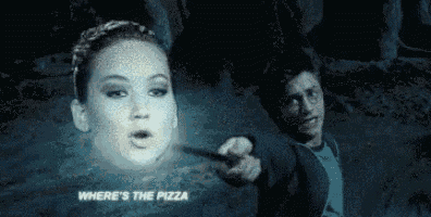 a man is holding a wand in front of a woman 's face in a cave .