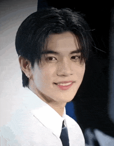 a young man wearing a white shirt and tie smiles for the camera