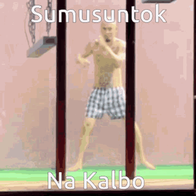 a man standing in a cage with the words sumusuntok na kalbo written above him