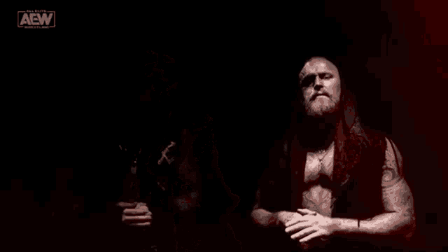 two men are standing next to each other in a dark room in a wrestling match .