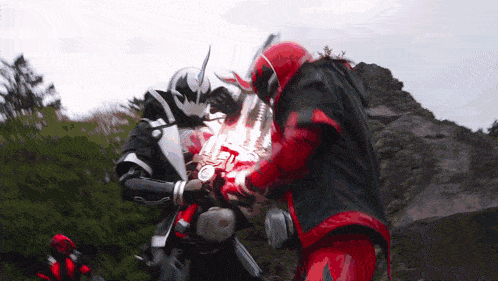 a couple of superheros are fighting each other in a field .