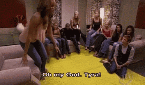 a group of people are sitting on couches in a living room and a woman is jumping on a couch .